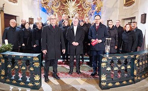 v.l.n.r.  Pfarrgemeindebegleiter Karl Ramsmaier, Bischof Scheuer, Moderator Günther Madlberger Im Hintergrund der Chor „Camerata Garstina“ unter der Leitung von Klaus Oberleitner.